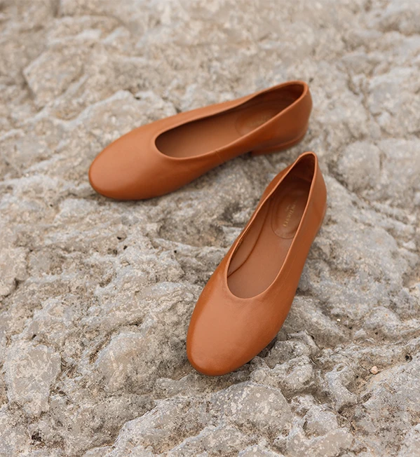 Mocassins camel Maison Toufet portés avec pantalon marron sur balcon