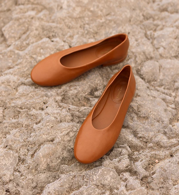 Mocassins camel Maison Toufet portés avec pantalon marron sur balcon