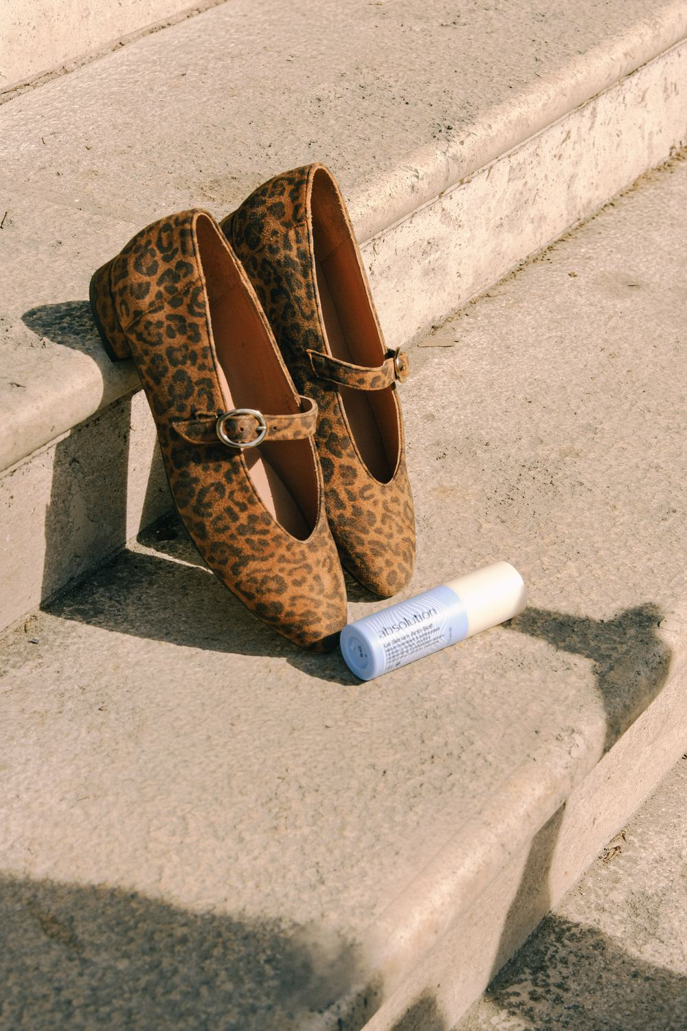 Ballerines Cassandre léopard Maison Toufet et Sérum Anti-Soif Absolution sur un escalier en pierre à Paris